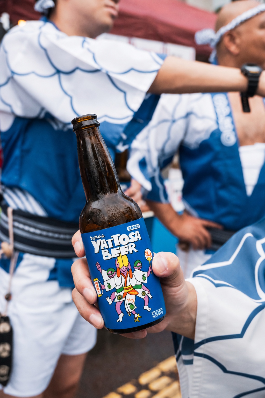 阿波踊りの会場でヤットサービールを掲げる