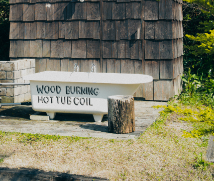 image: Open-air bath with wood fire cooking